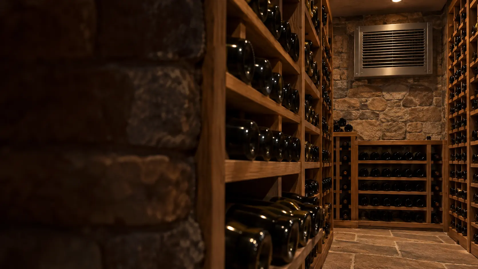 A wine cellar with a through-wall cooling unit and glass walls, seen close and low along the racks.